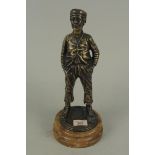 A bronze figure of a whistling street boy on a marble base,