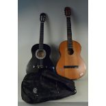 A black acoustic guitar in cloth case plus a Spanish acoustic guitar