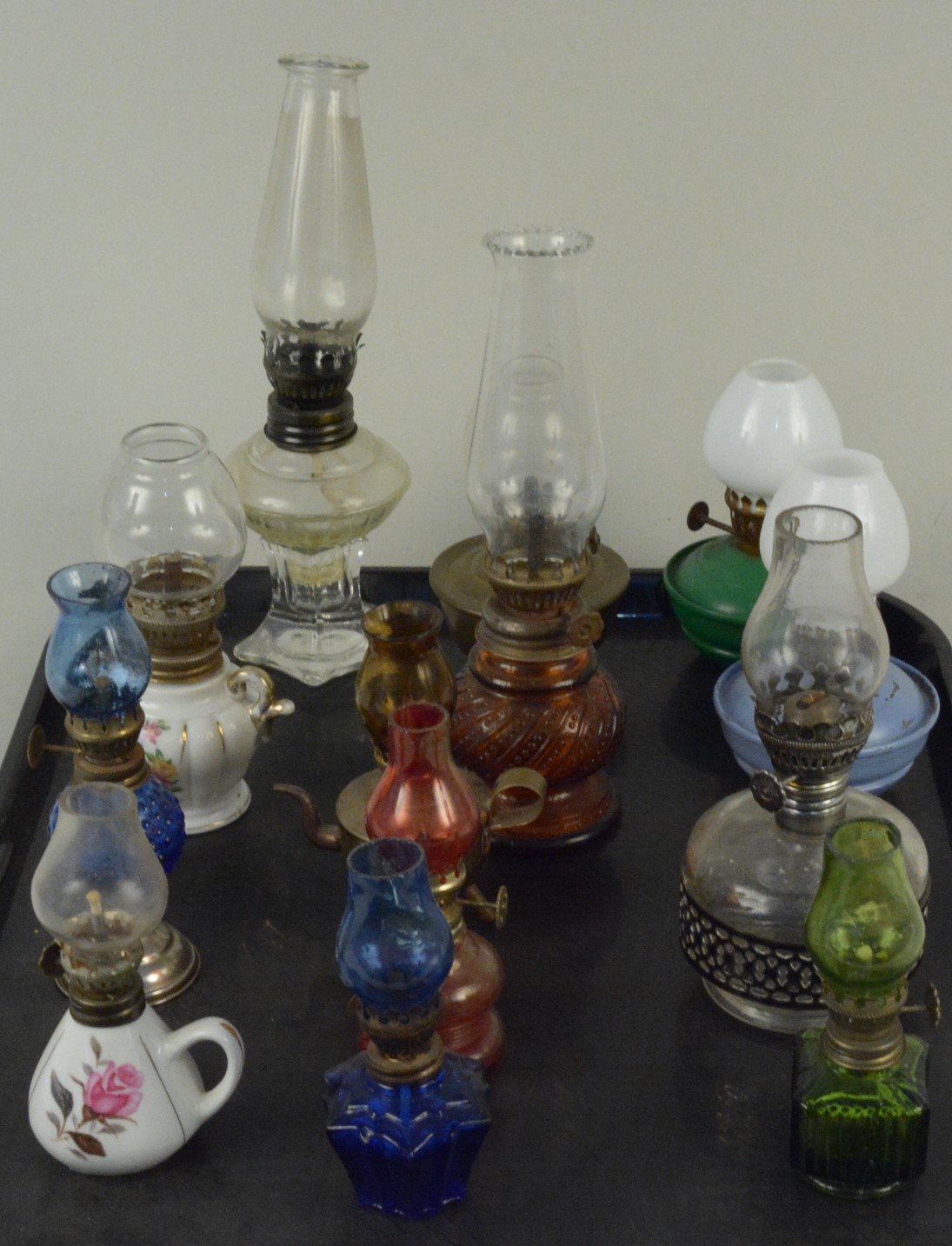 A collection of thirteen miniature oil lamps