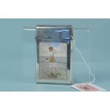 A silver card case with enamelled beach scene to both sides, one side with a lady paddling in water,