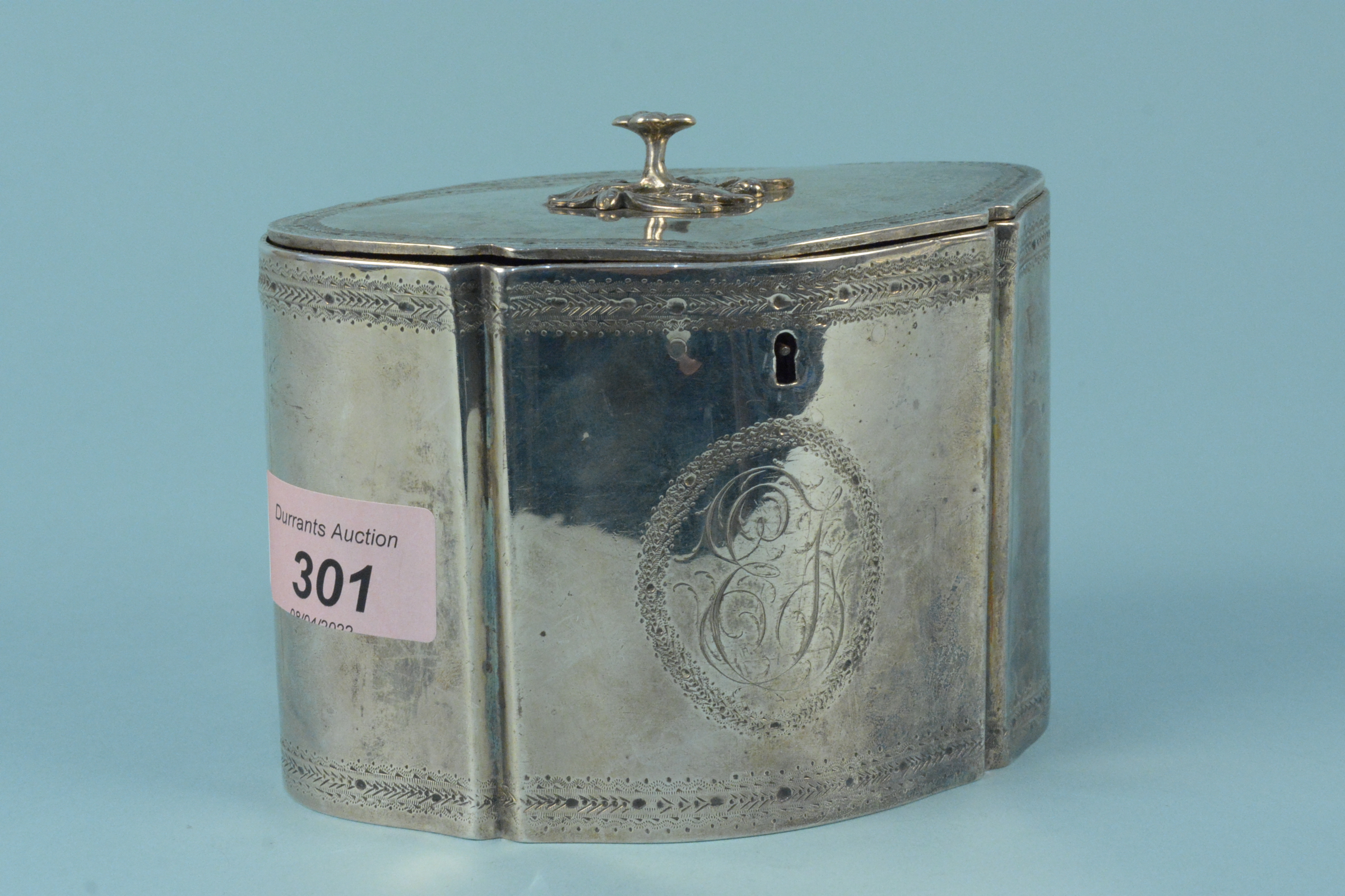 A Georgian silver tea caddy with engraved border and large monogram to centre with applied floral