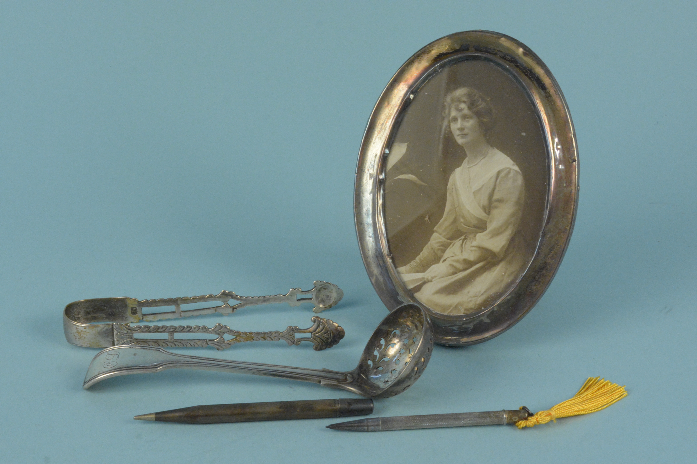 A Victorian silver sifting spoon, a pair of Georgian silver tongs (as found),