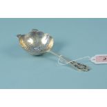 A silver tea strainer with pierced decoration to handle,