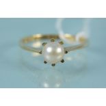 An unmarked yellow metal single pearl set ring, size P,