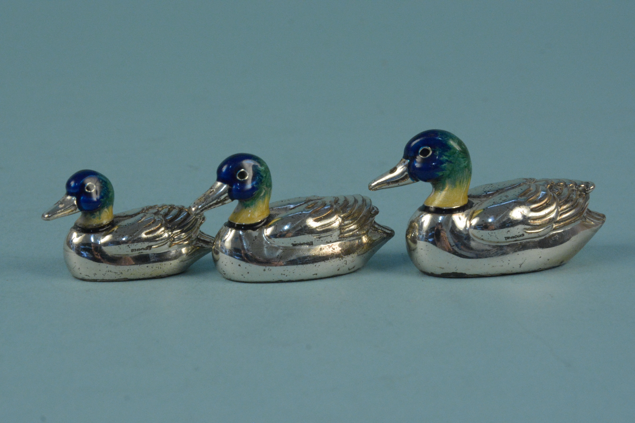 A graduating set of three silver enamelled ducks,