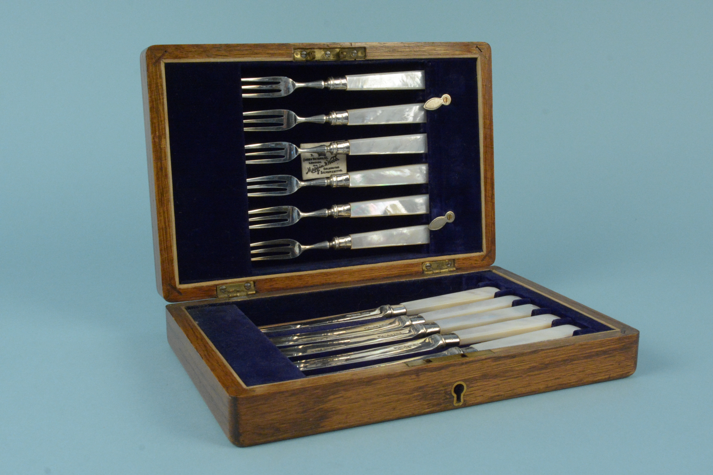 A cased set of six silver dessert knives and forks with mother of pearl handles (one knife is as