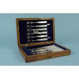 A cased set of six silver dessert knives and forks with mother of pearl handles (one knife is as