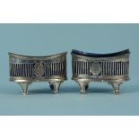 A pair of silver salts with pierced decoration on four feet, both engraved with crests,