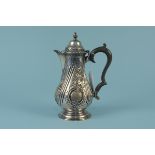 A Victorian silver coffee pot with embossed floral decoration on flared base, engraved with crest,