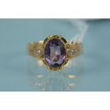 An 18ct gold oval amethyst set ring with diamond set shoulders, shank stamped 18C, size Q 1/2,