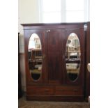 An Edwardian inlaid mahogany triple wardrobe