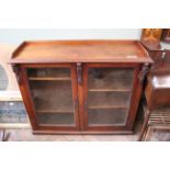 A Victorian mahogany and pine two door glazed bookcase with carved corbels