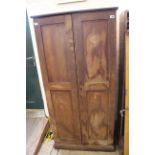 A late Victorian pine two door cupboard with shelved interior