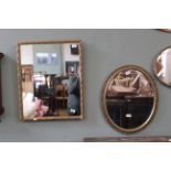 A 19th Century gilt wall mirror and a 20th Century oval gilt wall mirror
