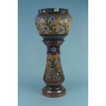 A c1890 Royal Doulton jardiniere and stand decorated with blue floral sprays against a bark effect