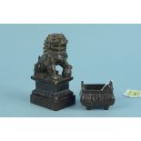 An antique bronze Chinese temple dog on wooden base, 11.