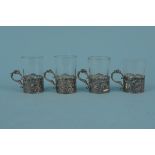 A set of four continental silver shot glass holders with pierced and embossed decoration,