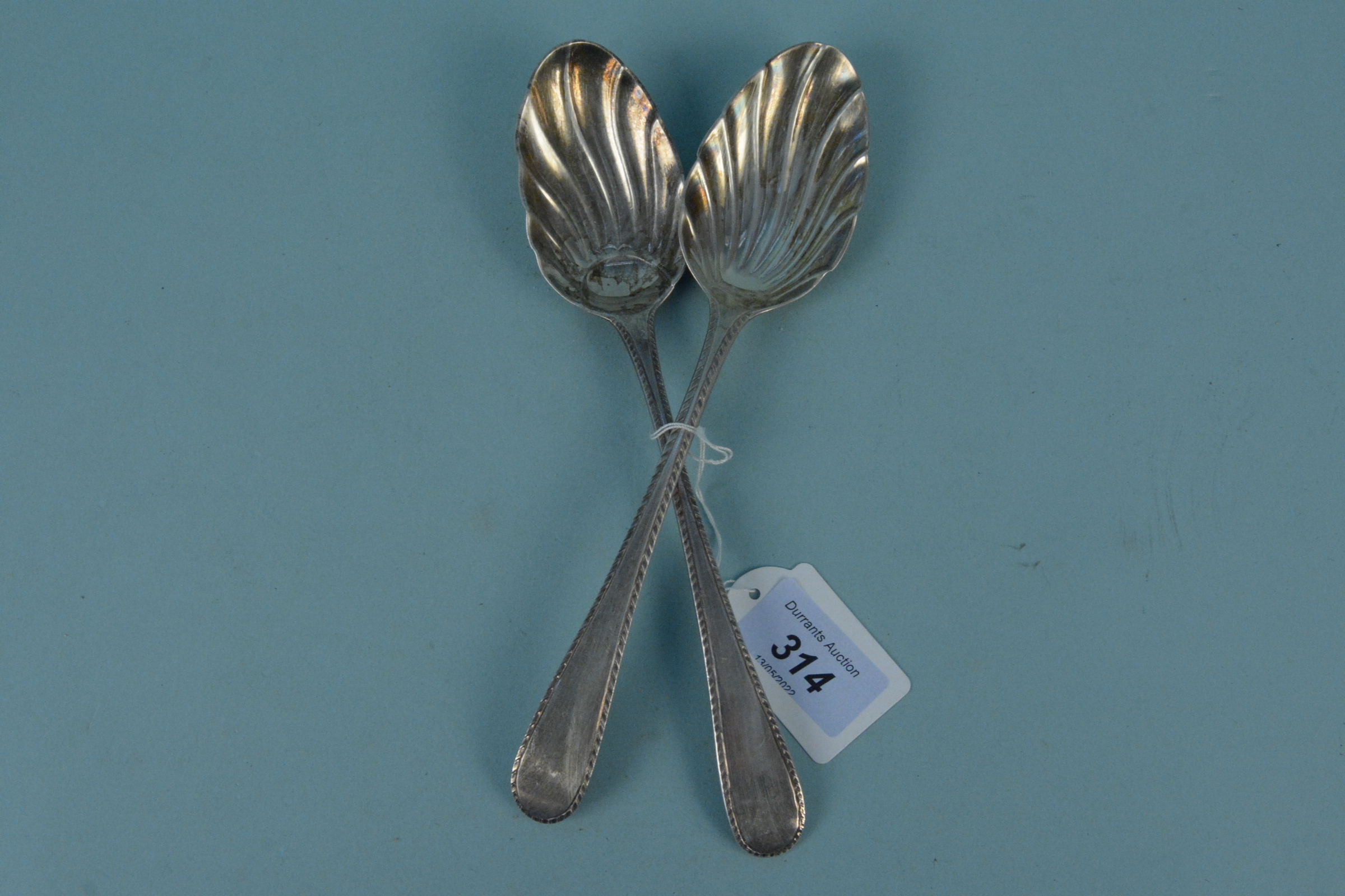 Two similar Georgian silver spoons with patterned bowls (one rubbed marks),