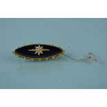 An unmarked yellow metal mourning brooch with jet panel applied yellow metal seed pearl set star
