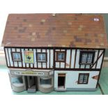 A vintage dolls house 'The Old Curiosity Shop' of wood construction and hand painted design,