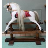 A vintage painted rocking horse on pine base