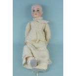 A large porcelain headed Victorian doll in period dress with blue sleeping eyes and open mouth with