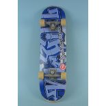 A 2005 McGill skate board with blue graffiti graphics (wear to edges)