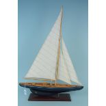 A wooden built model yacht with linen sails and mounted on wooden base,