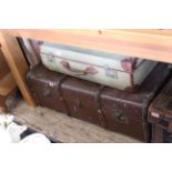 A vintage steamer trunk and a canvas suitcase