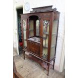 An Edwardian inlaid mahogany display cabinet with mirrored centre and under tier