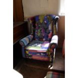 A modern wing back armchair upholstered with bright multi patterned material