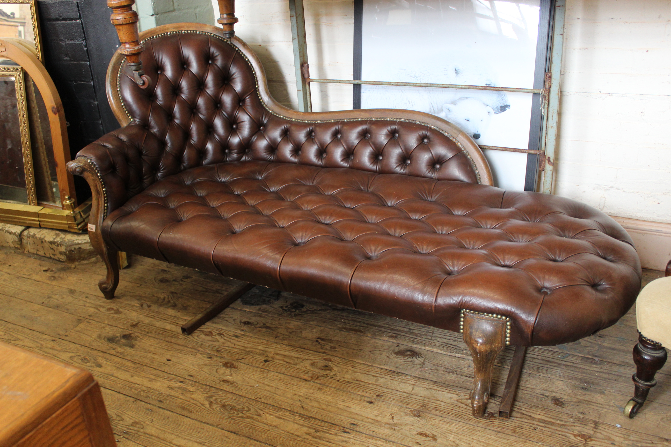 A late 19th Century beech and leather chaise longue, approx.