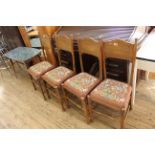 A set of four Arts and Crafts country made oak dining chairs with woolwork seats