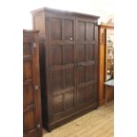 A 1930's Jacobean revival oak panelled wardrobe (no back)