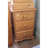 A modern pine three drawer bedside chest