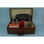A vintage leather suitcase containing a BOC soda siphon and Sparklets bulbs,
