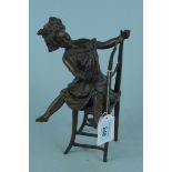 A 20th Century bronze of a girl sat upon a chair