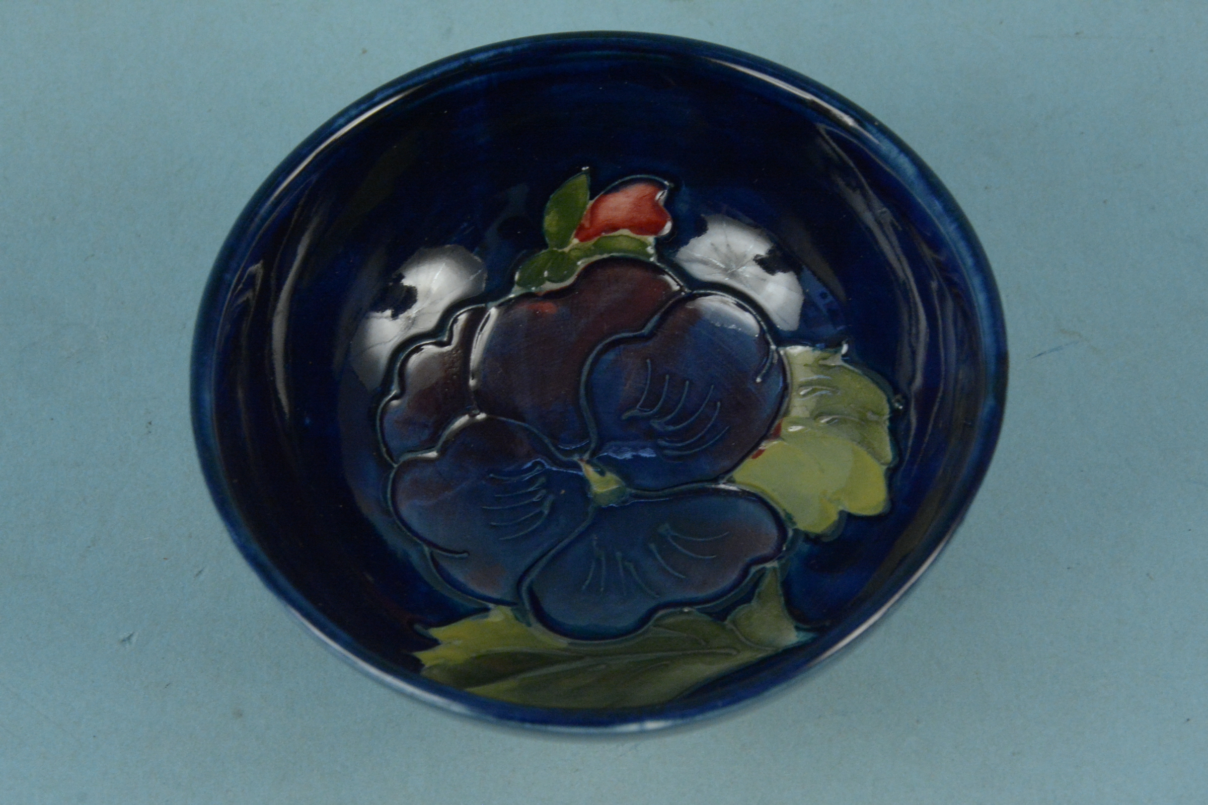 A Moorcroft small bowl, the interior decorated with a blue pansy,