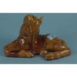 A 20th Century studio pottery treacle glazed recumbent foal