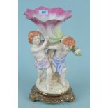 A Capodimonte style figurine of two children carrying a stylised lily