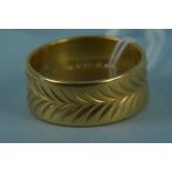 A large 22ct gold wedding band with engraved decoration, size S,
