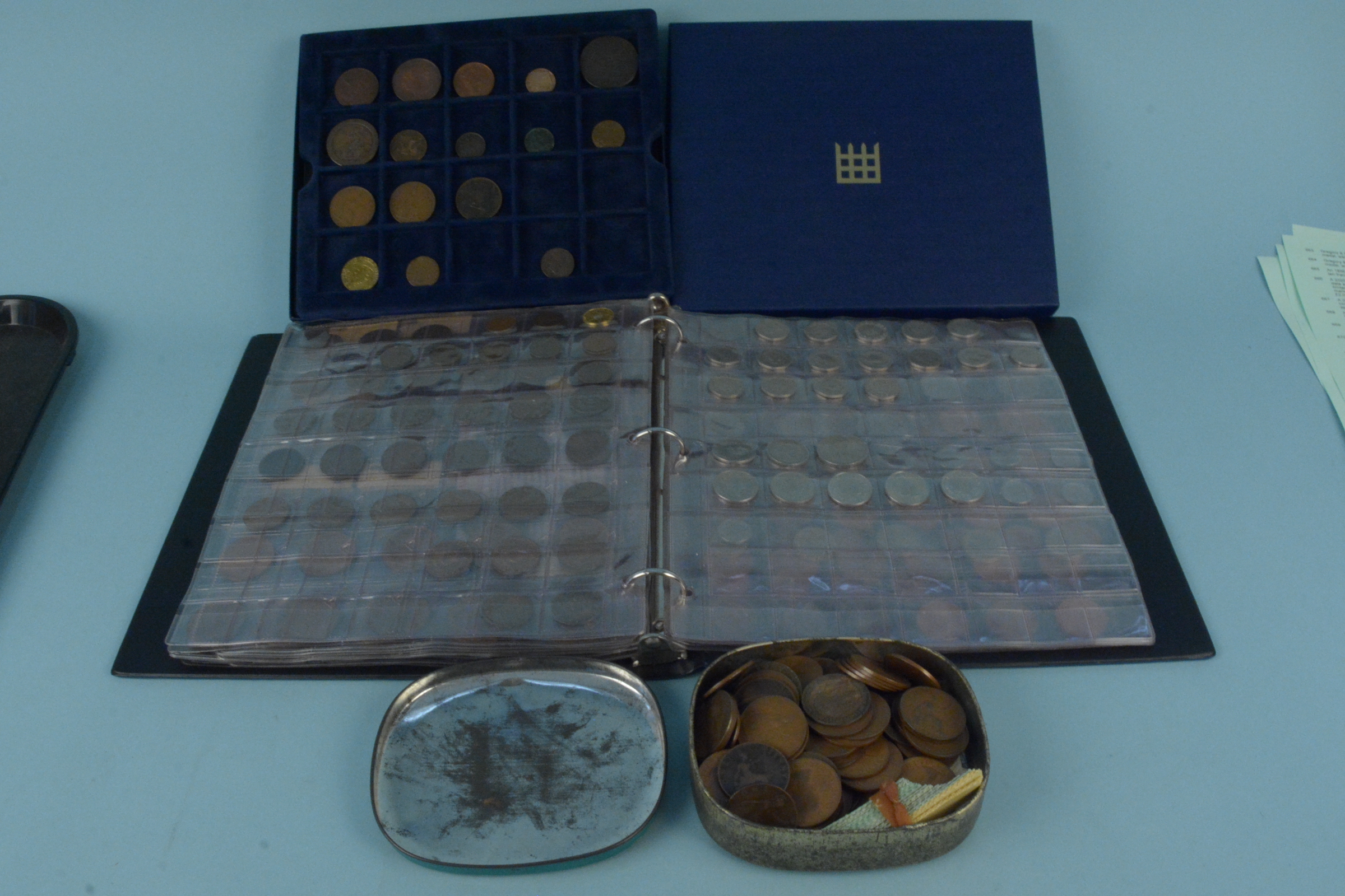 A folder containing British coins including some silver with old milled copper coins in a box plus