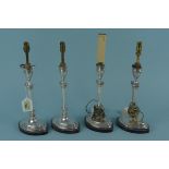 A set of four silver candlesticks, later converted for electricity,