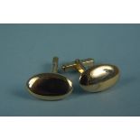 A pair of yellow metal oval form cufflinks of plain design, stamped 18,