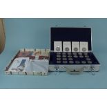 An aluminium coin case containing £5 commemorative coins, some in packs, total face value of £165,