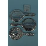 Three silver hand mirrors plus a silver book front with embossed couple scene