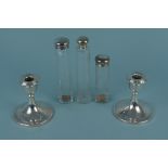 A pair of dwarf silver candlesticks (rub marks and dented) together with silver lidded glass