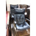 A pair of black leatherette and ply framed lounge chairs