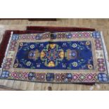 A hand woven wool blue ground rug approx.