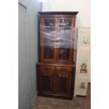 An Edwardian carved oak cupboard bookcase with adjustable shelves